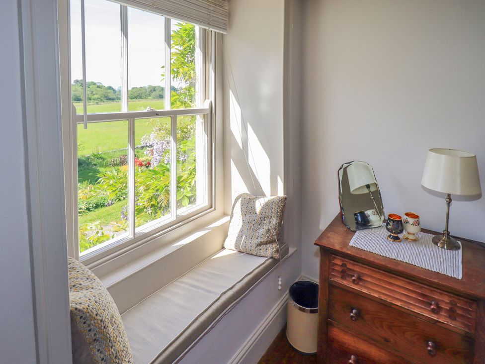 A bedroom with a window seat and a dresser at Bridge End Cottage Haverthwaite near Cartmel