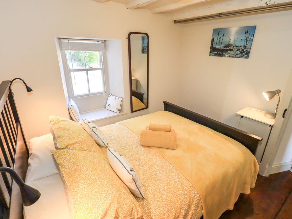 A bedroom with a bed and window at Bridge End Cottage, Haverthwaite near Cartmel