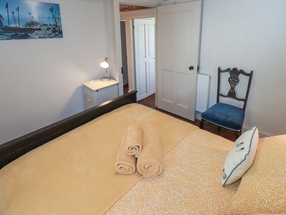 A bedroom with a bed and towels on the sheets at Bridge End Cottage Haverthwaite near Cartmel