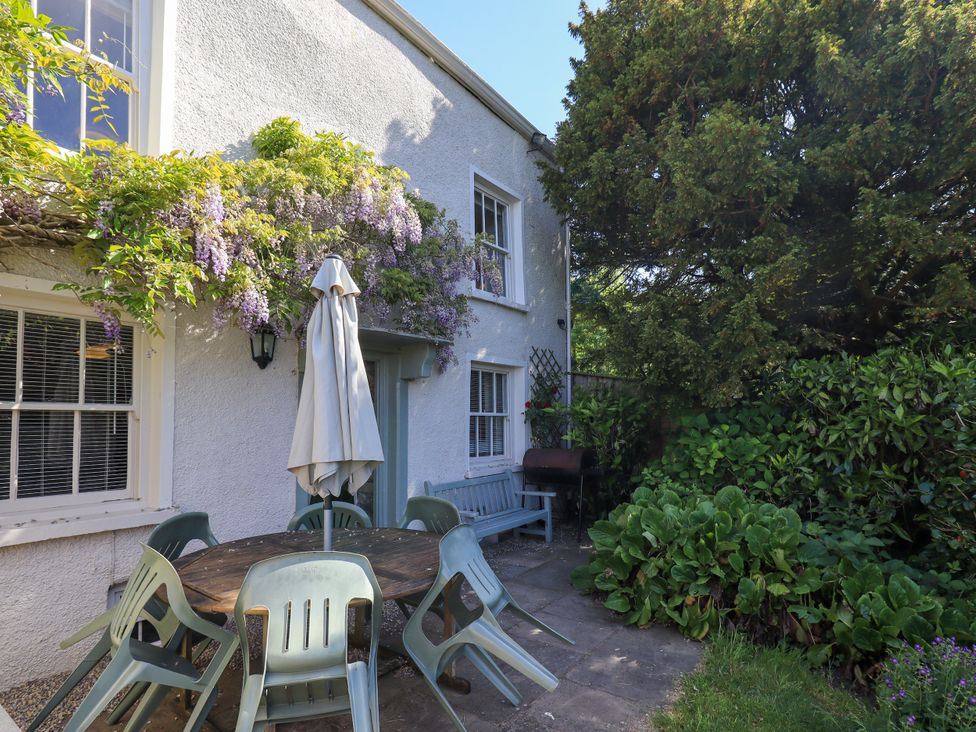 An outdoor patio with a table and chairs at Bridge End Cottage in Haverthwaite near Cartmel