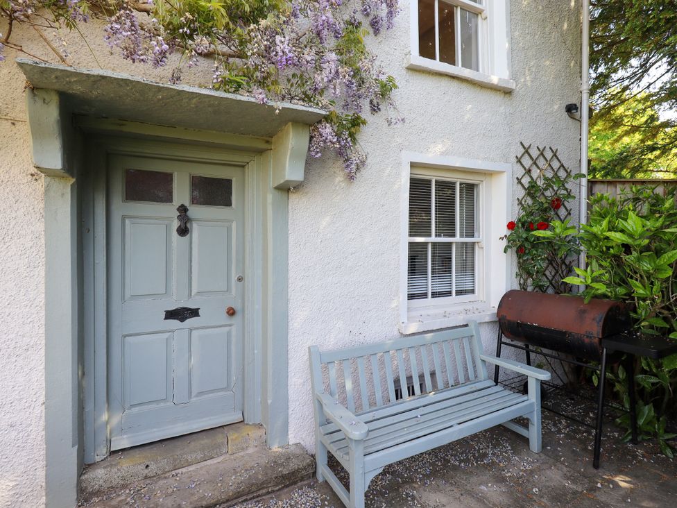 An outdoor view of a door and bench at Bridge End Cottage Haverthwaite near Cartmel