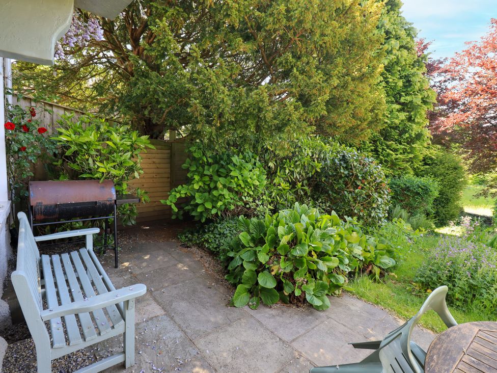 A garden with a bench and barbecue at Bridge End Cottage Haverthwaite near Cartmel