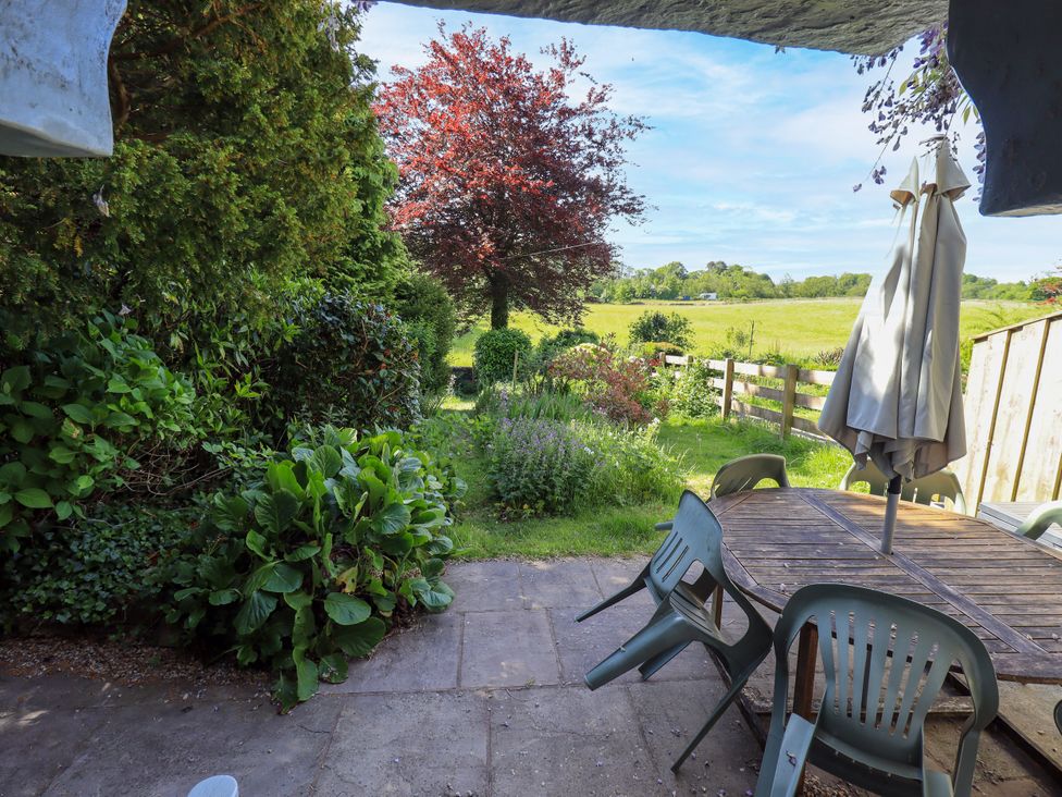 A garden with a table and chairs at Bridge End Cottage Haverthwaite near Cartmel