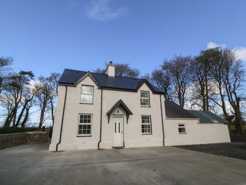 A house with a driveway and trees at Gate House, Capel Coch near Llanerchymedd