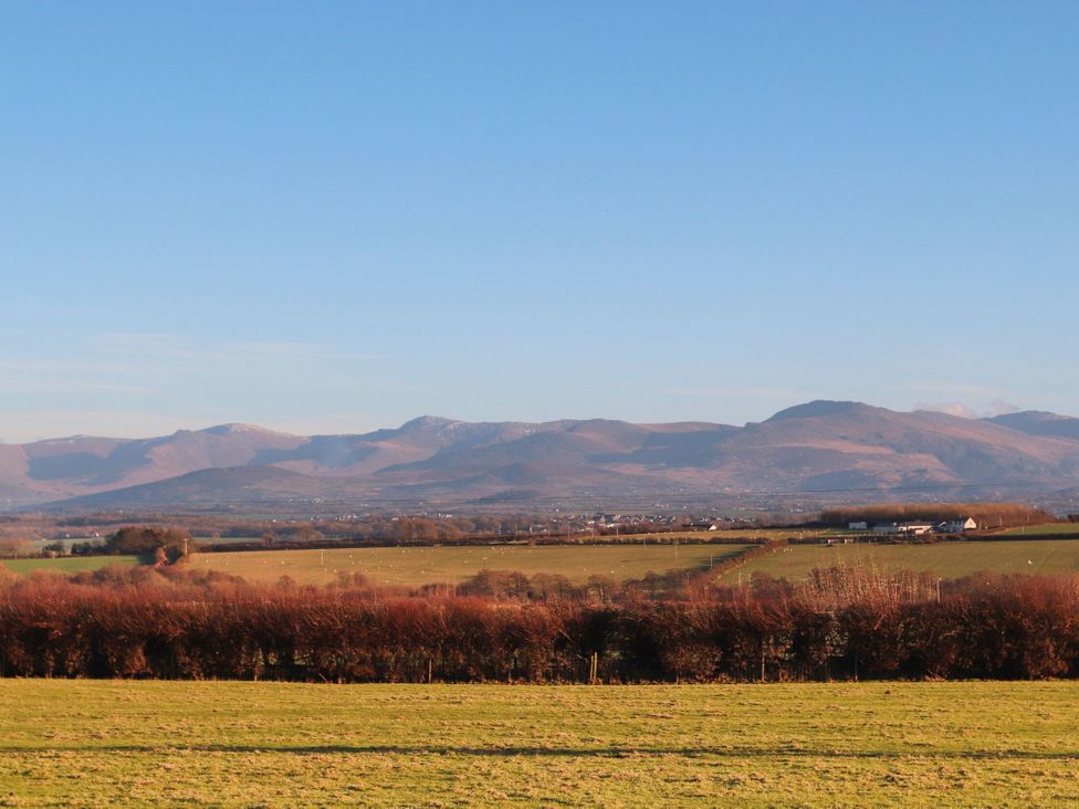 A scenic view of mountains and fields at Gate House Capel Coch near Llanerchymedd