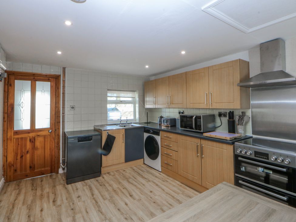 A kitchen with appliances and cabinets at Gate House in Capel Coch near Llanerchymedd