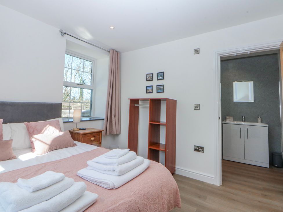 A bedroom with a bed and vanity unit at Gate House Capel Coch near Llanerchymedd