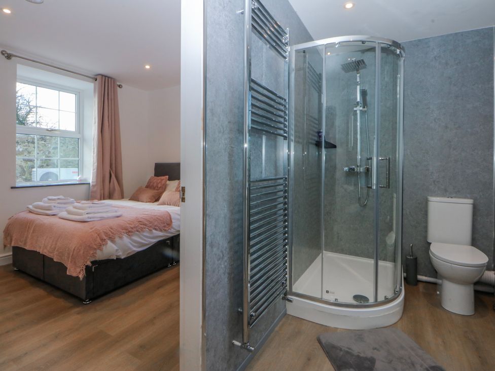 A bedroom with a bed and bathroom facilities at Gate House Capel Coch near Llanerchymedd