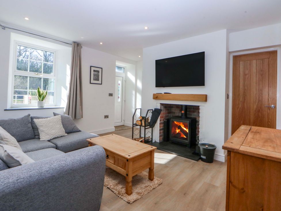 A living room with a sofa and fireplace at Gate House Capel Coch near Llanerchymedd