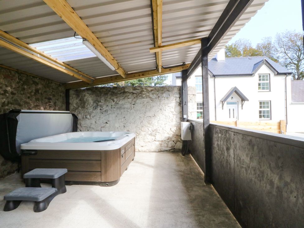 A hot tub with steps in an outdoor area at Gate House Capel Coch near Llanerchymedd
