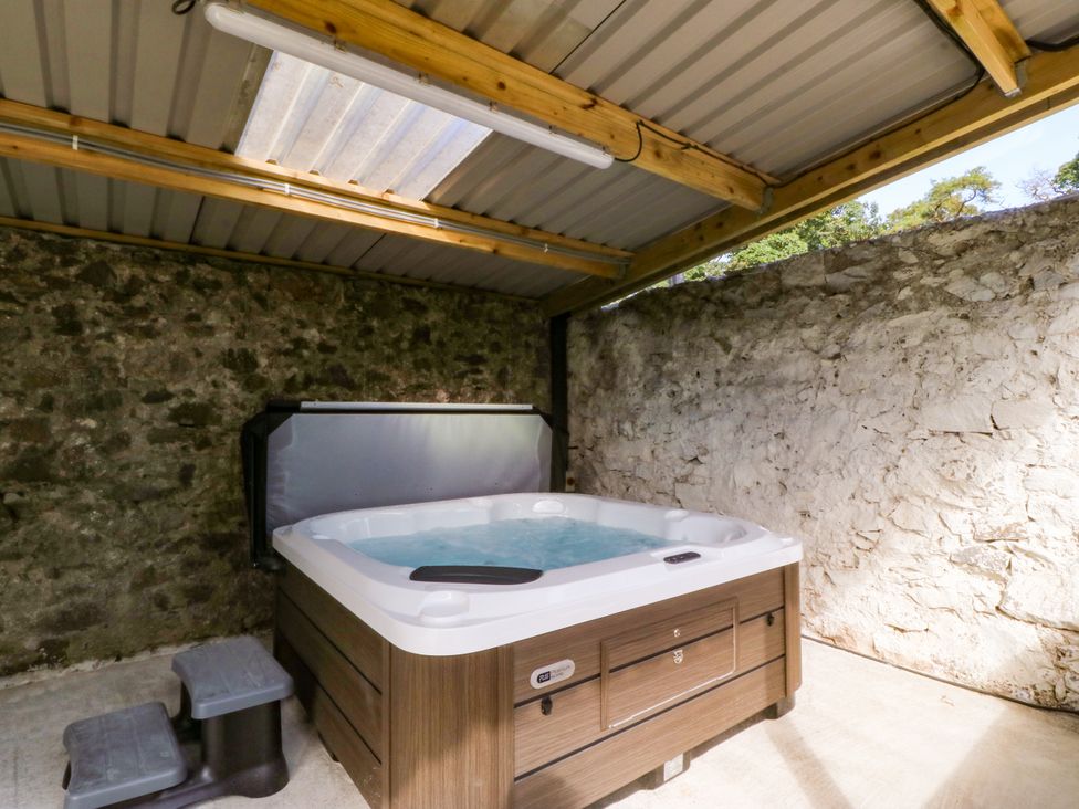 A hot tub with steps in an indoor area at Gate House in Capel Coch near Llanerchymedd