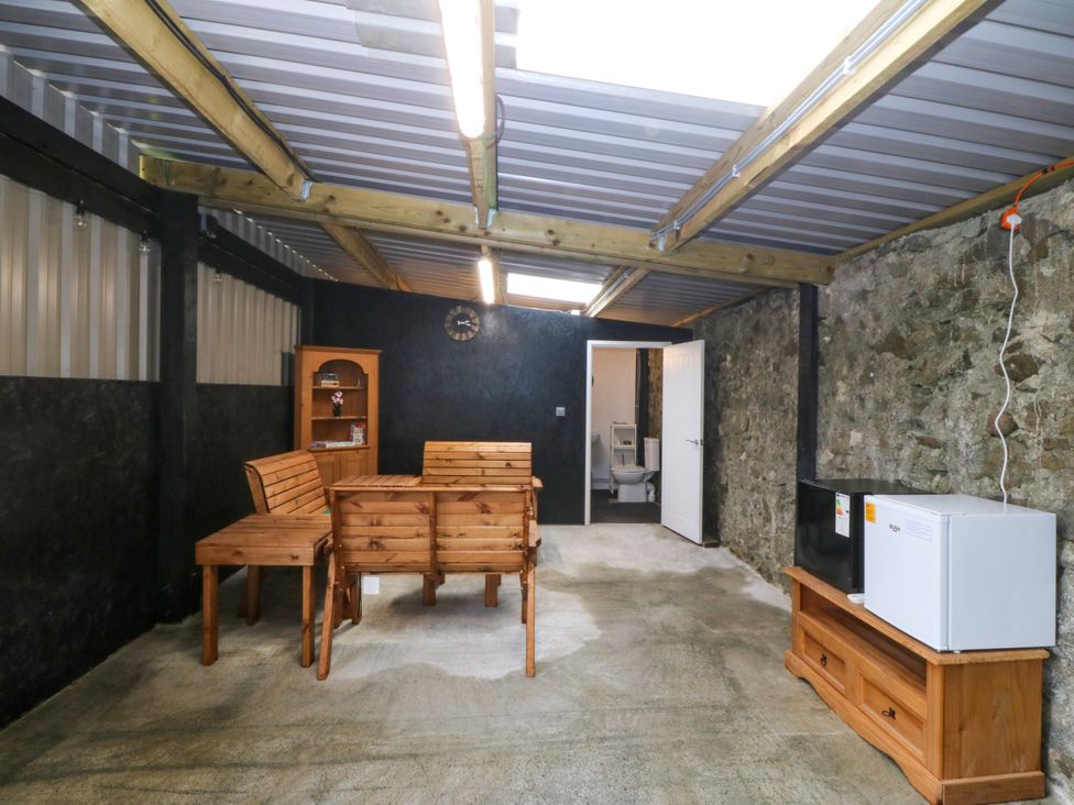 A room with wooden furniture and appliances at Gate House near Llanerchymedd