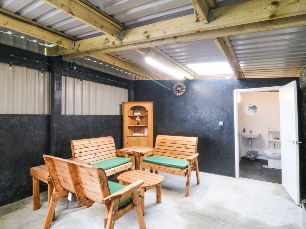 A snug with wooden seating and a small bathroom area at Gate House Capel Coch near Llanerchymedd