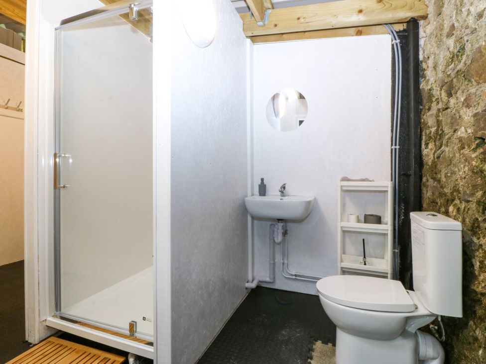 A bathroom with a shower a sink and a toilet at Gate House Capel Coch near Llanerchymedd