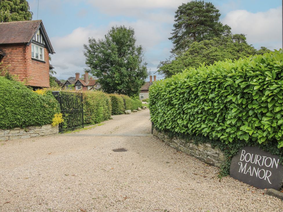 An entrance path with a gate and surrounding greenery at The Butler’s Quarters in Bourton near Much Wenlock