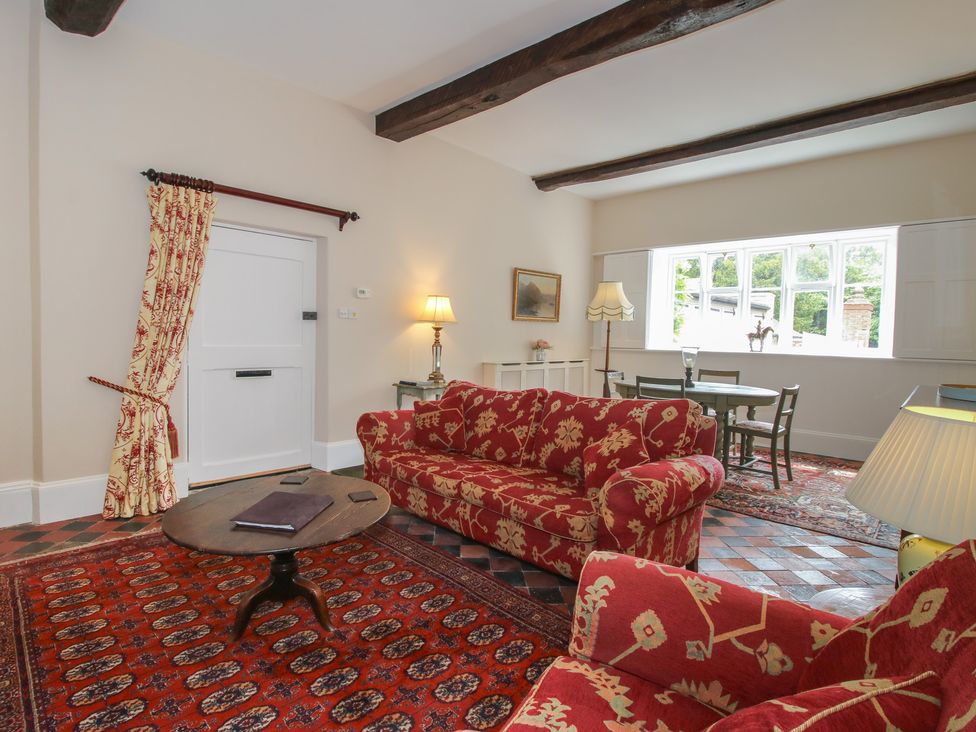 A living room with sofas and a table at The Butler’s Quarters in Bourton near Much Wenlock