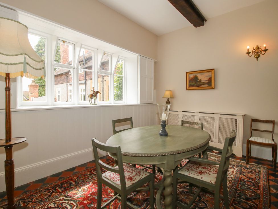 A dining room with a round table and chairs at The Butler’s Quarters in Bourton near Much Wenlock