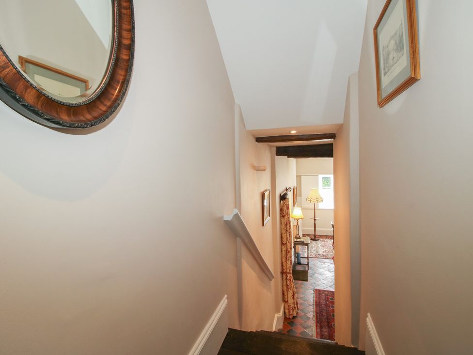 A staircase leading to a room with a lamp and rug at The Butler’s Quarters in Bourton near Much Wenlock