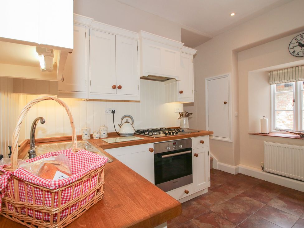 A kitchen with a stove and sink at The Butler’s Quarters in Bourton near Much Wenlock