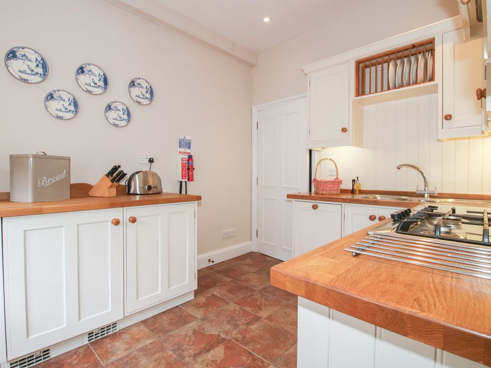 A kitchen with cabinets, a sink, and a stove at The Butler’s Quarters in Bourton near Much Wenlock