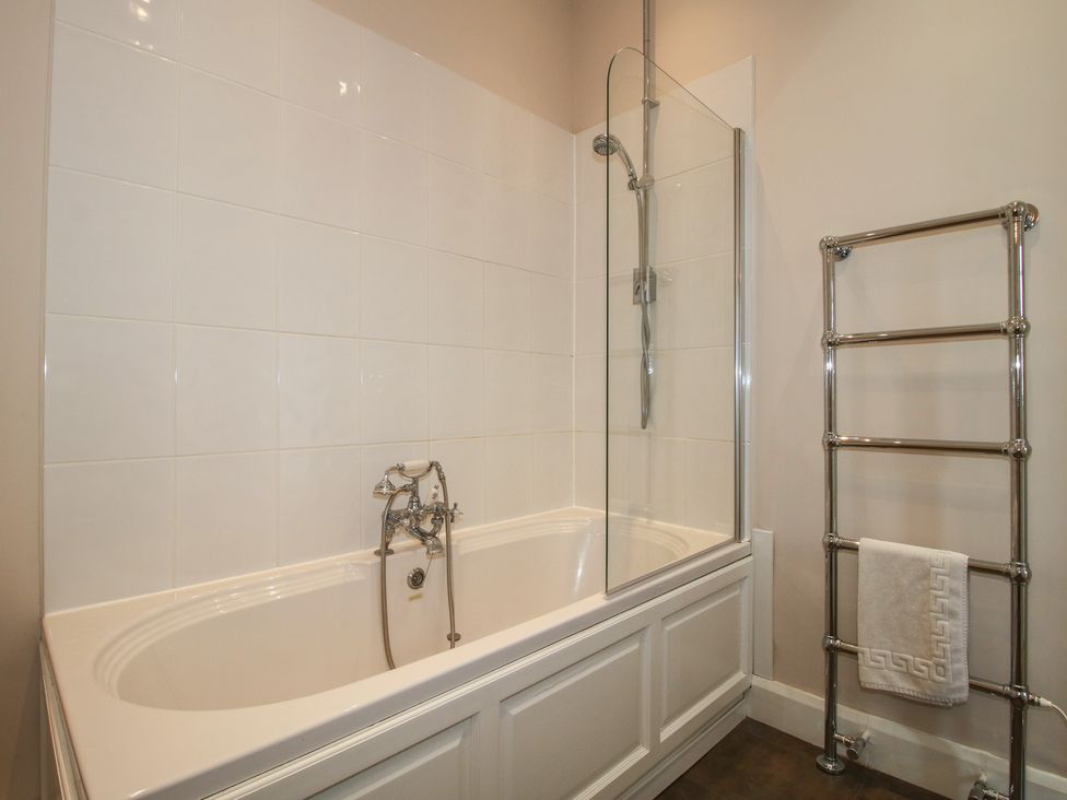 A bathroom with a bathtub and shower at The Butler’s Quarters Bourton near Much Wenlock