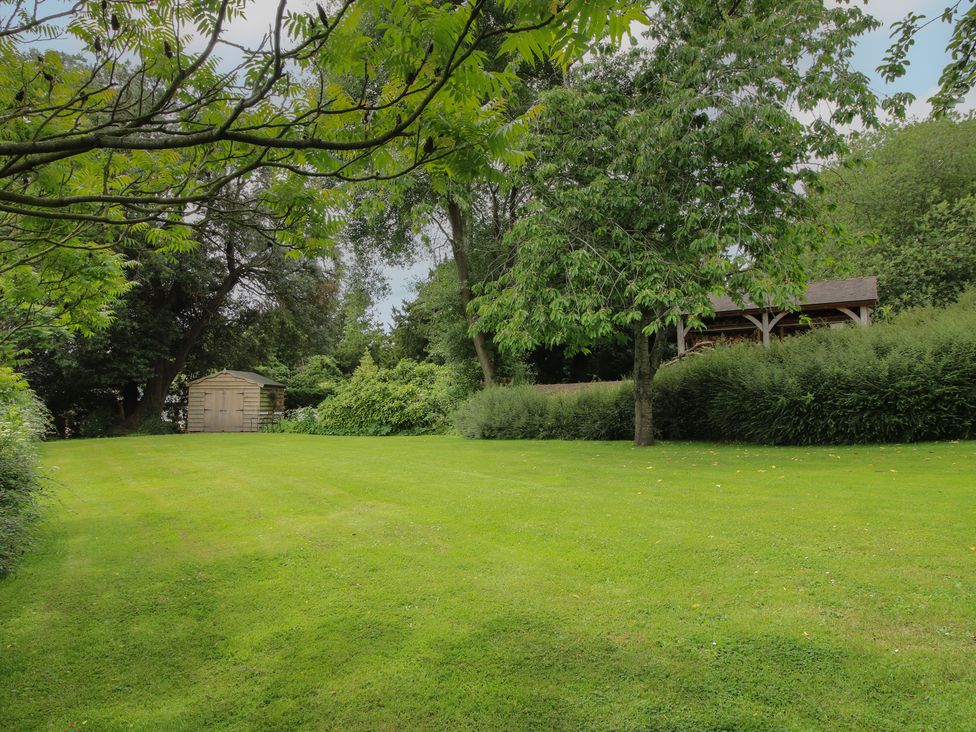 A garden with grass and trees at The Butler’s Quarters near Bourton near Much Wenlock