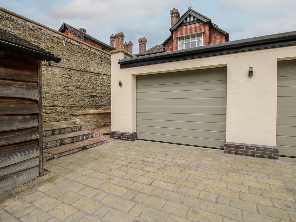 A paved driveway leading to garage doors at The Butler’s Quarters Bourton near Much Wenlock