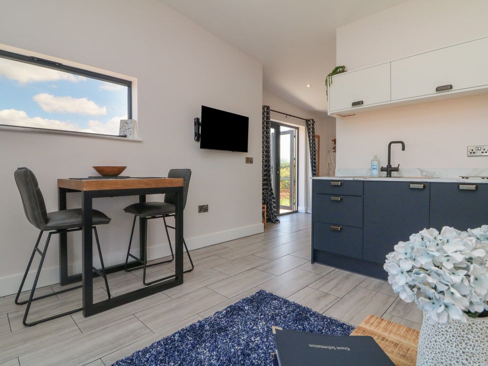 A kitchen with a dining table and chairs at The Cadeleigh near Tiverton