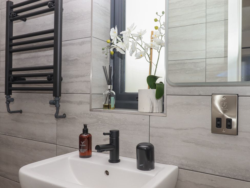 A bathroom with a sink, faucet, and towel radiator at The Cadeleigh near Tiverton