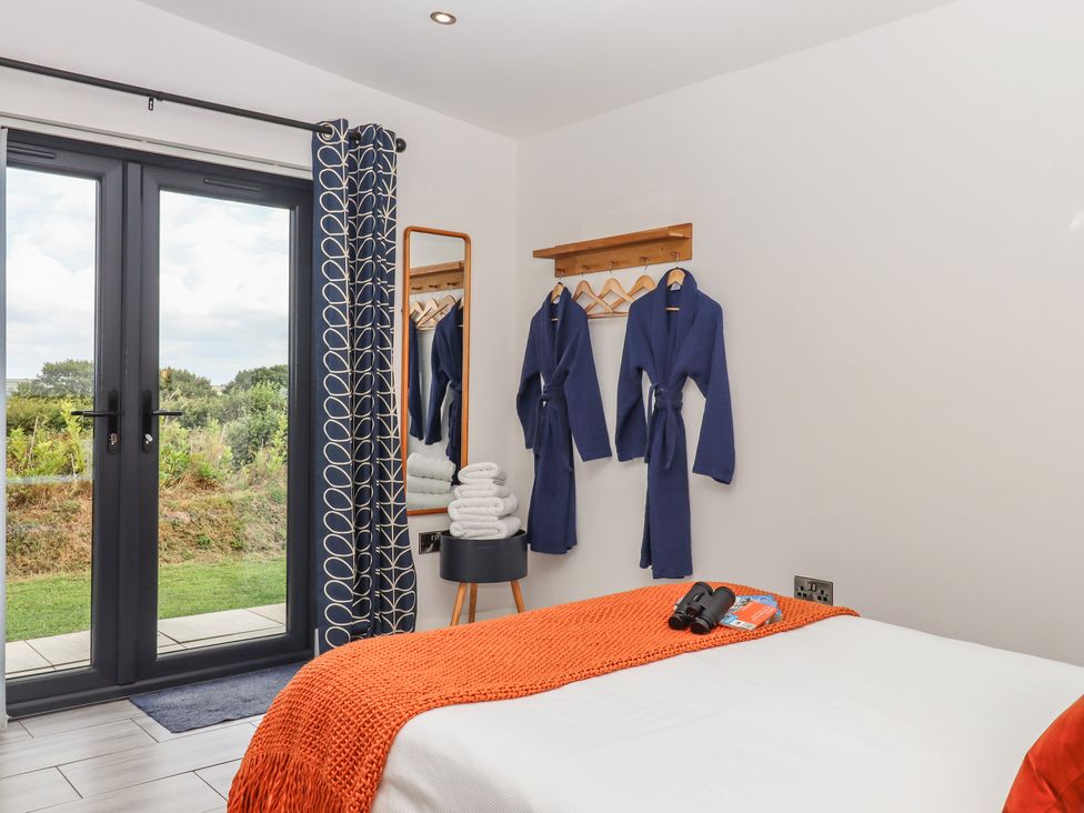A bedroom with a bed and wardrobe robes at The Cadeleigh Cadeleigh near Tiverton