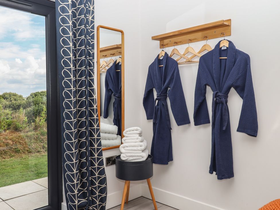 A bathroom with bathrobes and towels at The Cadeleigh near Tiverton
