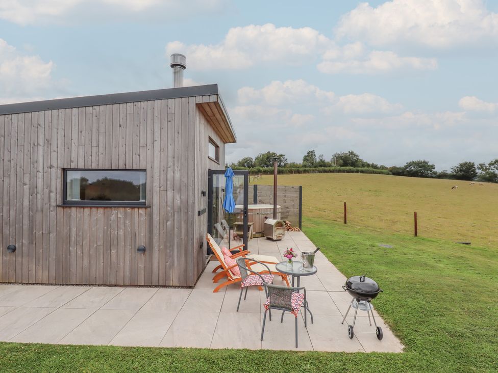 A patio with chairs and a table at The Cadeleigh near Tiverton