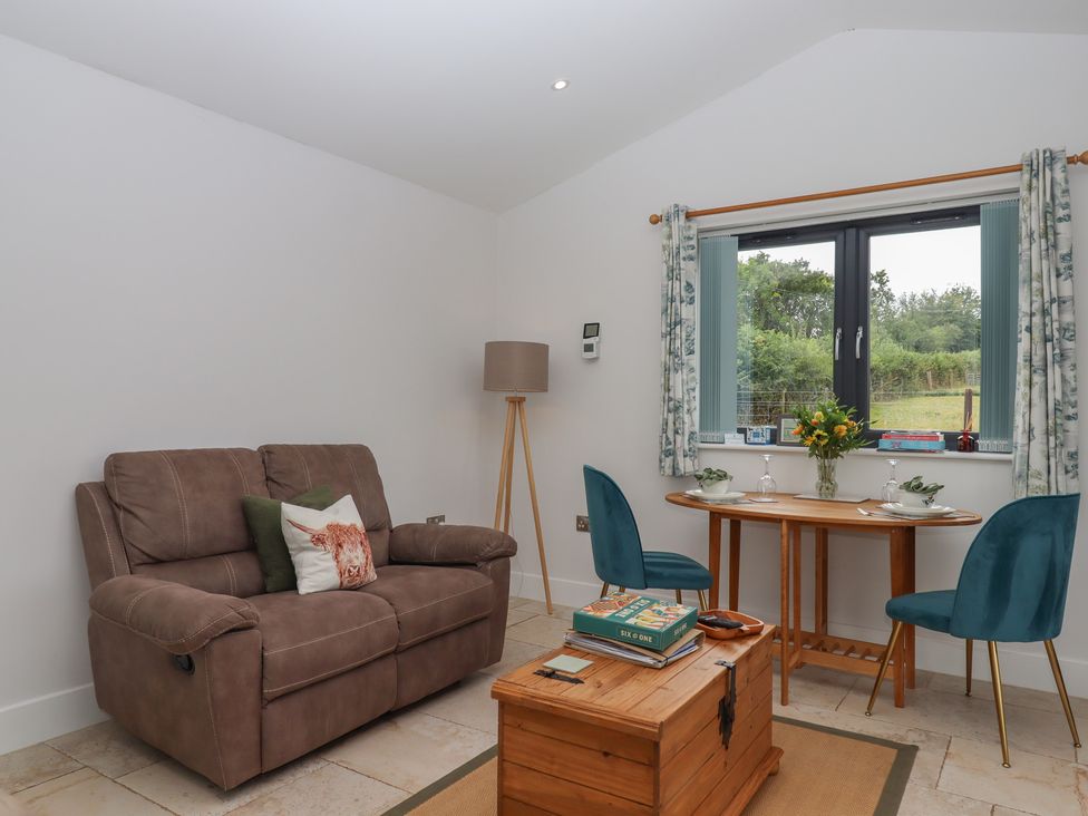 A snug with a sofa and table at The Pennymoor in Cadeleigh near Tiverton