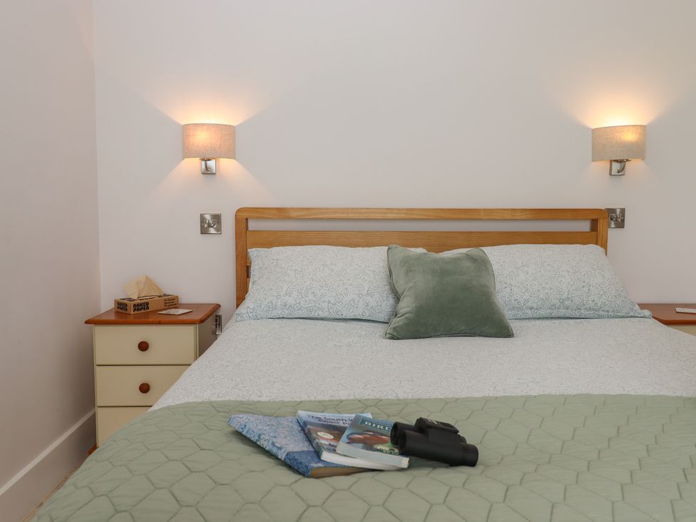 A bedroom with a bed and nightstand at The Pennymoor in Cadeleigh near Tiverton