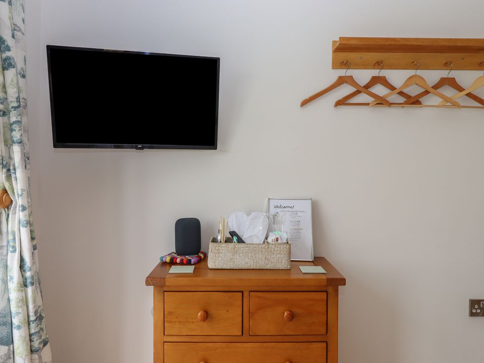 A bedroom with a television and a storage unit at The Pennymoor in Cadeleigh near Tiverton