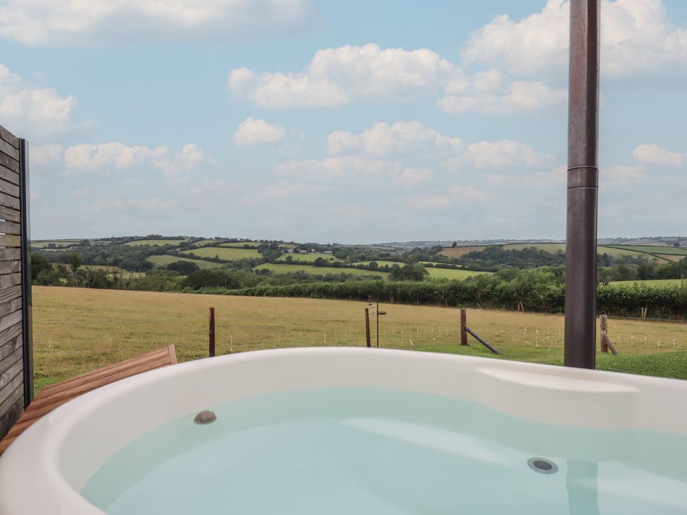 A hot tub on a wooden deck overlooking the countryside at The Bickleigh in Cadeleigh near Tiverton