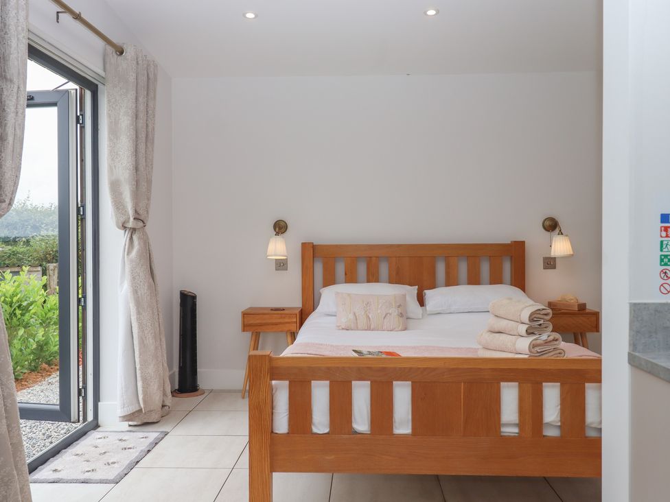 A bedroom with a bed and bedside table at The Bickleigh in Cadeleigh near Tiverton