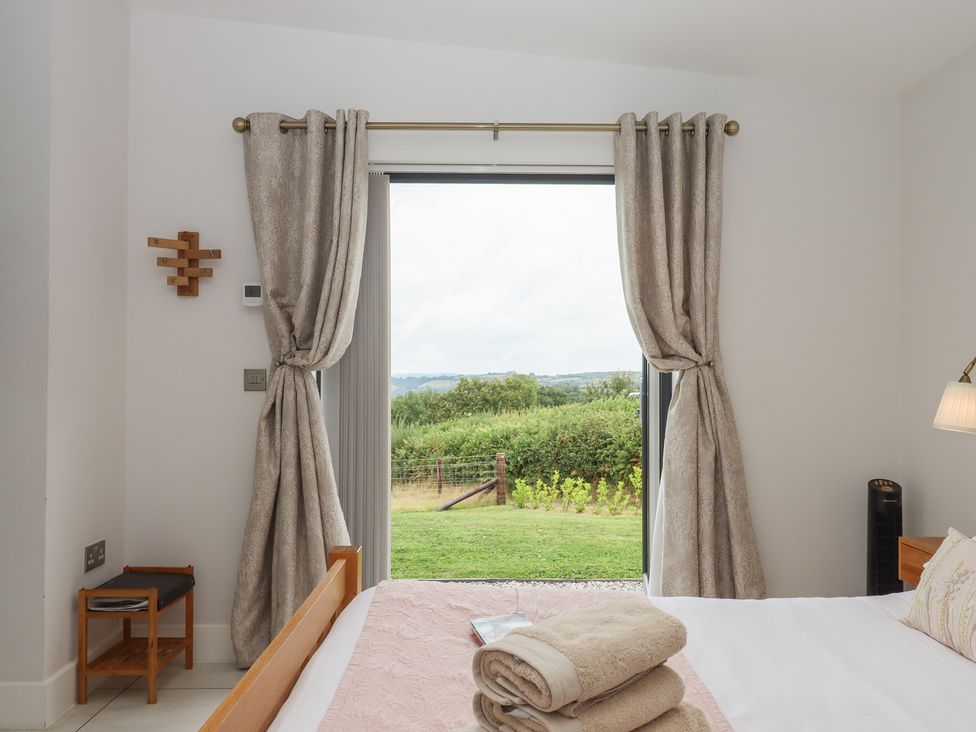 A bedroom with a bed and view of outdoor landscape at The Bickleigh in Cadeleigh near Tiverton