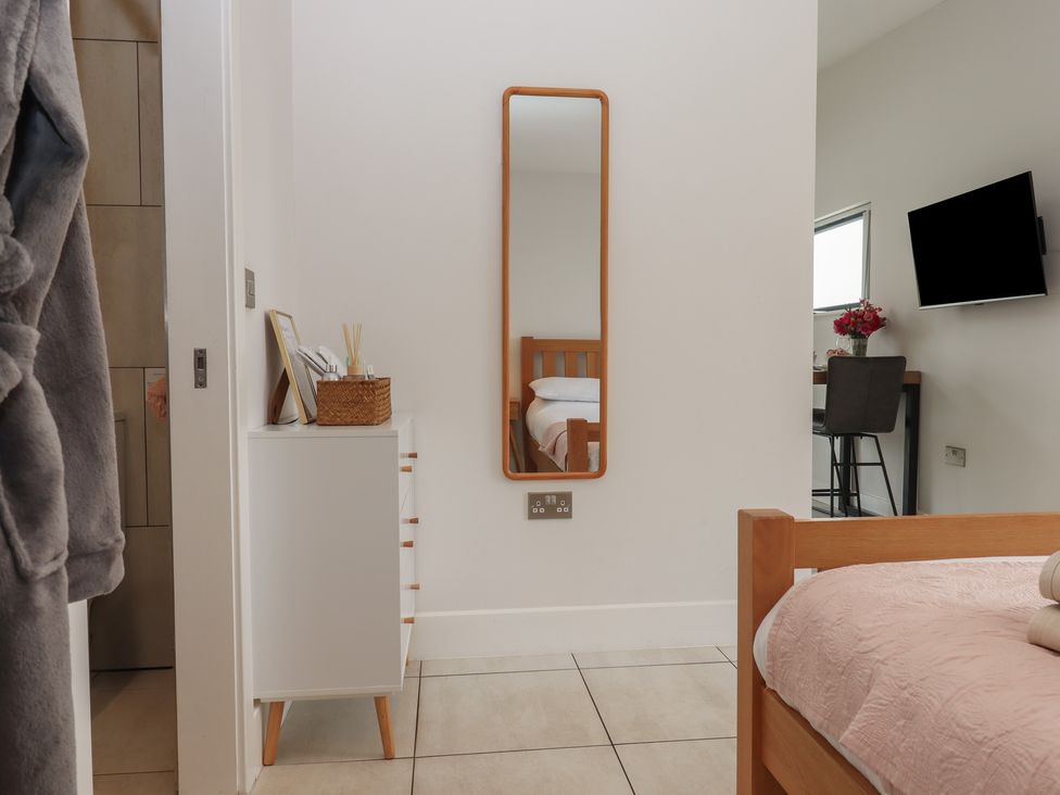 A bedroom with a bed and a mirror at The Bickleigh in Cadeleigh near Tiverton