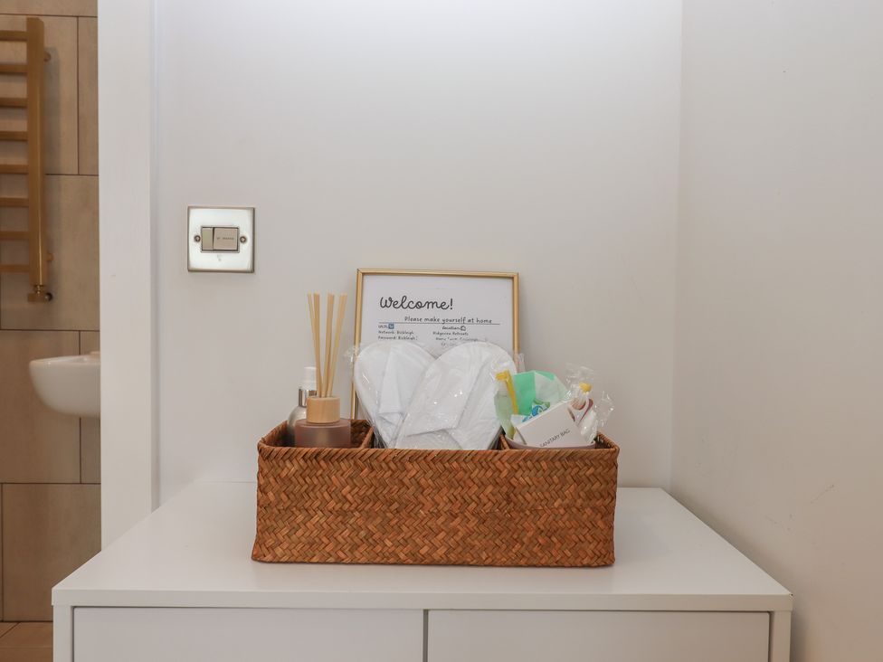 A bathroom counter with a basket of toiletries at The Bickleigh in Cadeleigh near Tiverton