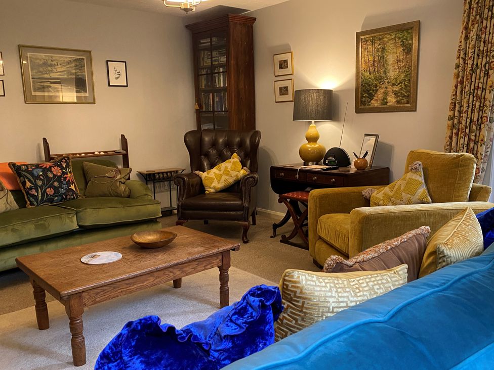 A living room with a green sofa and yellow armchair at Greywalls in Maulds Meaburn