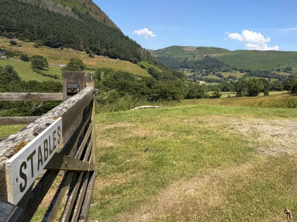 A view of a gate with a sign in front of a field at Graig Las The Stables Llanrhaeadr-Ym-Mochnant