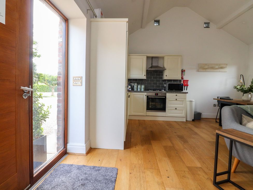 A kitchen with cabinets and appliances at The Stables in Hall Green near Walmer Bridge