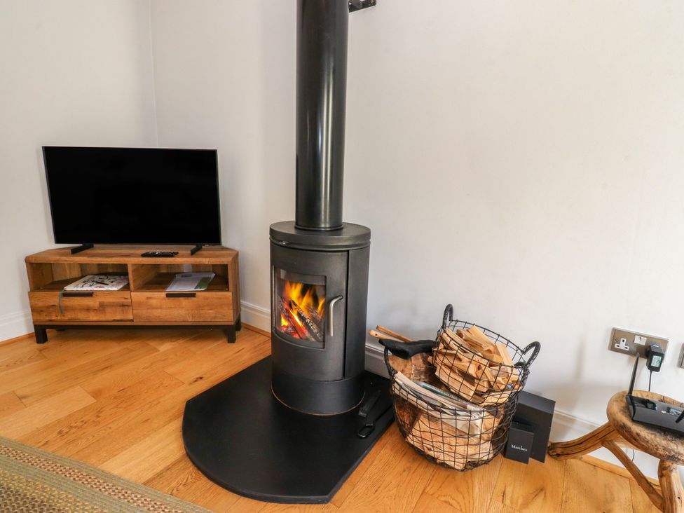 A living room with a wood stove and television at The Stables Hall Green near Walmer Bridge