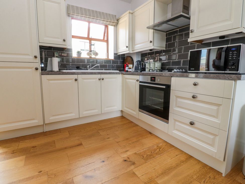 A kitchen with cabinets, oven, and microwave at The Stables in Hall Green near Walmer Bridge