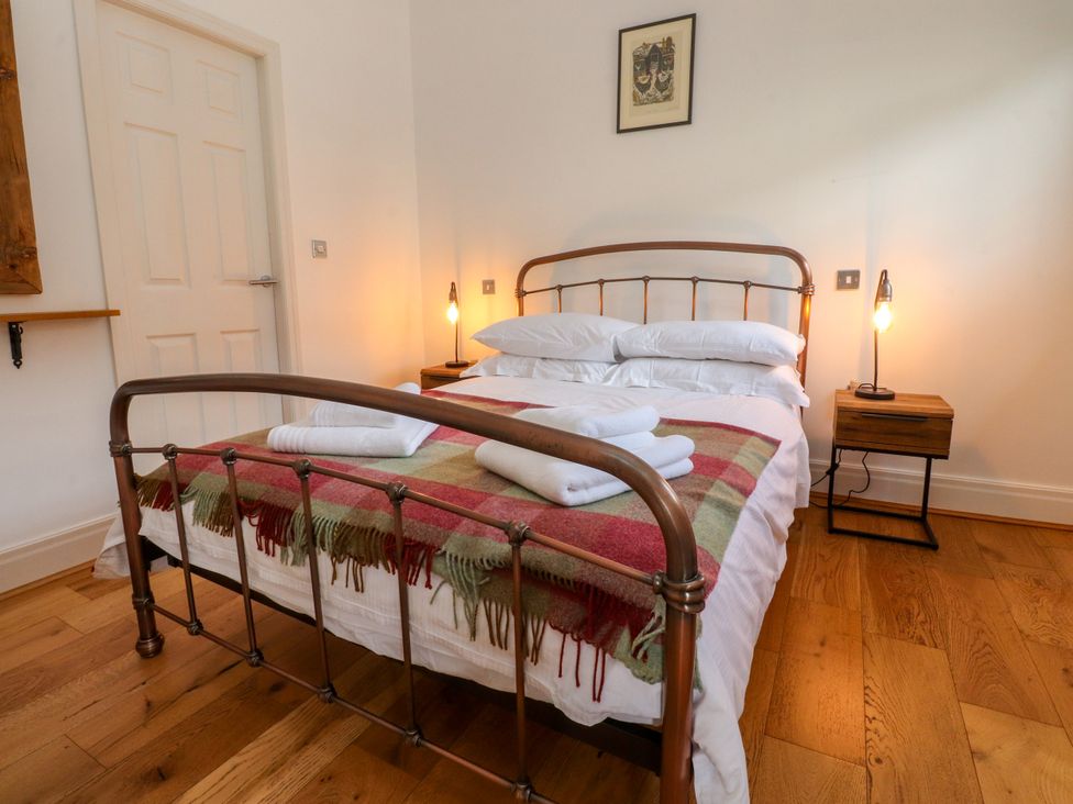 A bedroom with a bed and bedside table at The Stables in Hall Green near Walmer Bridge