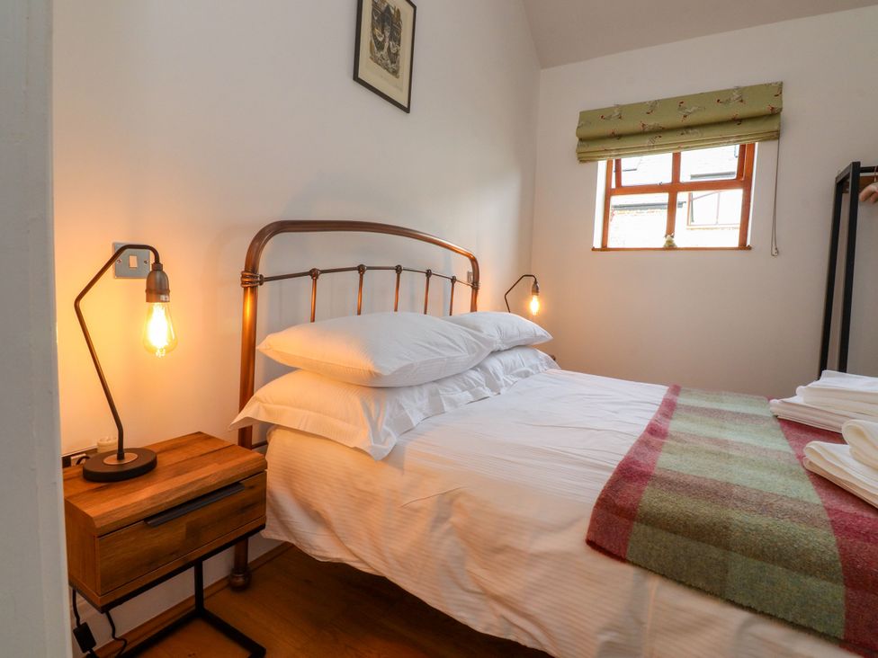 A bedroom with a bed and nightstand at The Stables Hall Green near Walmer Bridge