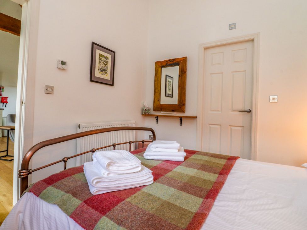 A bedroom with a bed and towels on it at The Stables Hall Green near Walmer Bridge