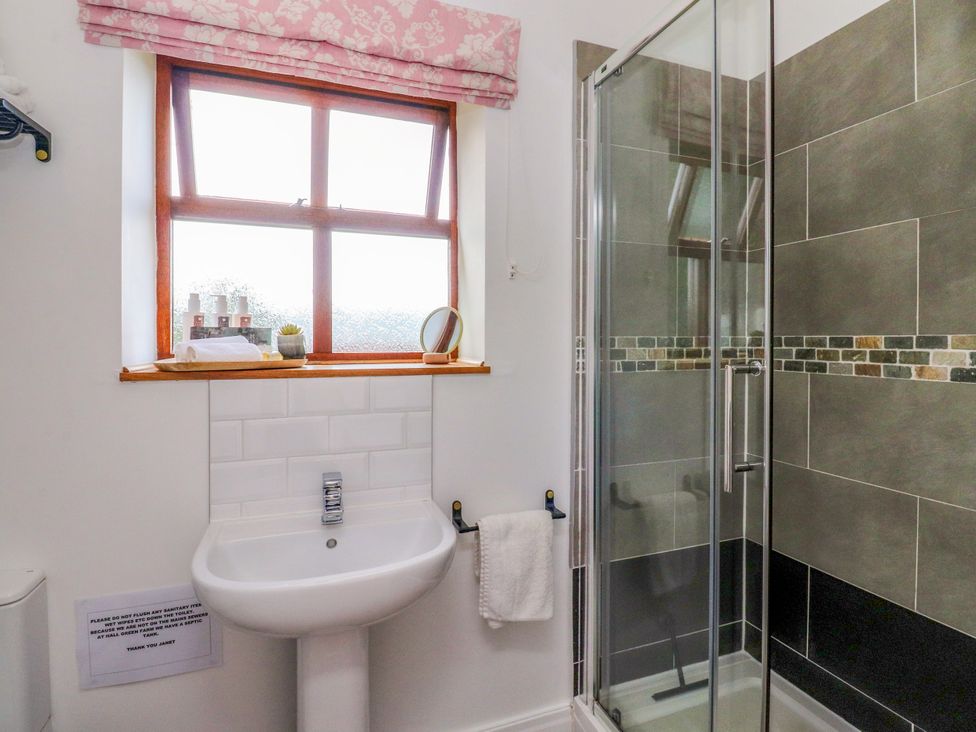 A bathroom with a sink and shower at The Stables in Hall Green near Walmer Bridge