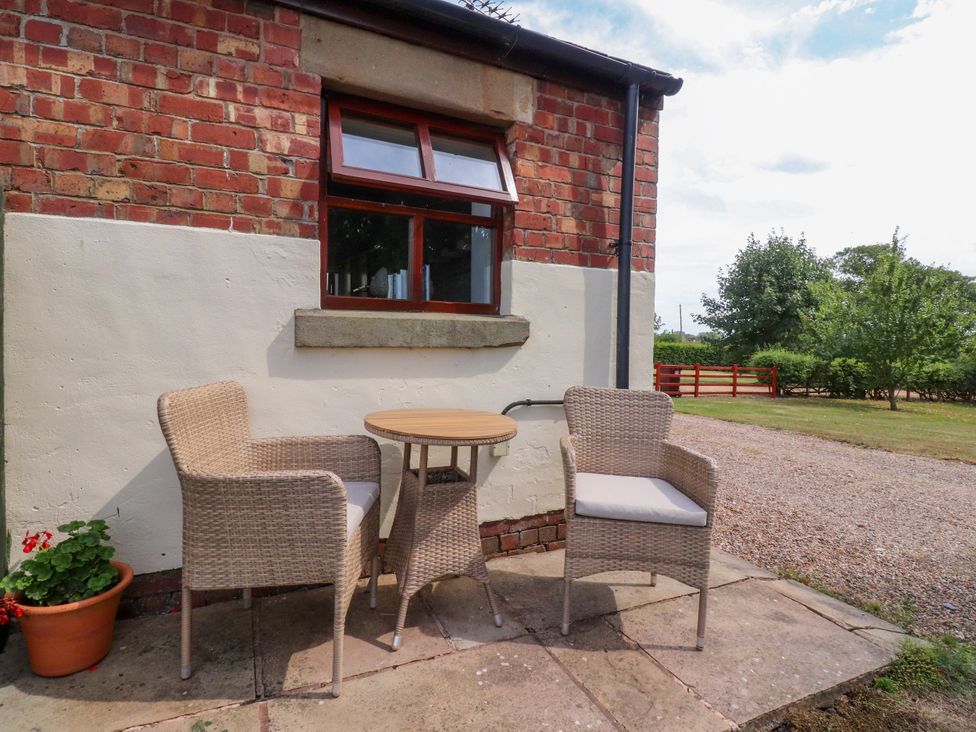 An outdoor seating area with chairs and a table at The Stables Hall Green near Walmer Bridge